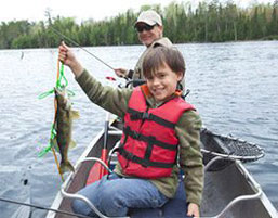 Possum Lodge Cabins - Photo of a man and boy fishing on a boat.