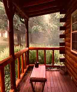 Romantic Cabin Rentals - A photo of a porch with a beautiful woodscape background. Possum lodge is your romantic Ohio cabin getaway.